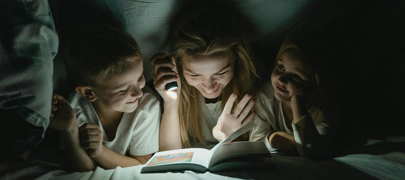 Mom reading to kids with Flashlight