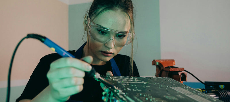Woman Soldering with Safety Goggles on